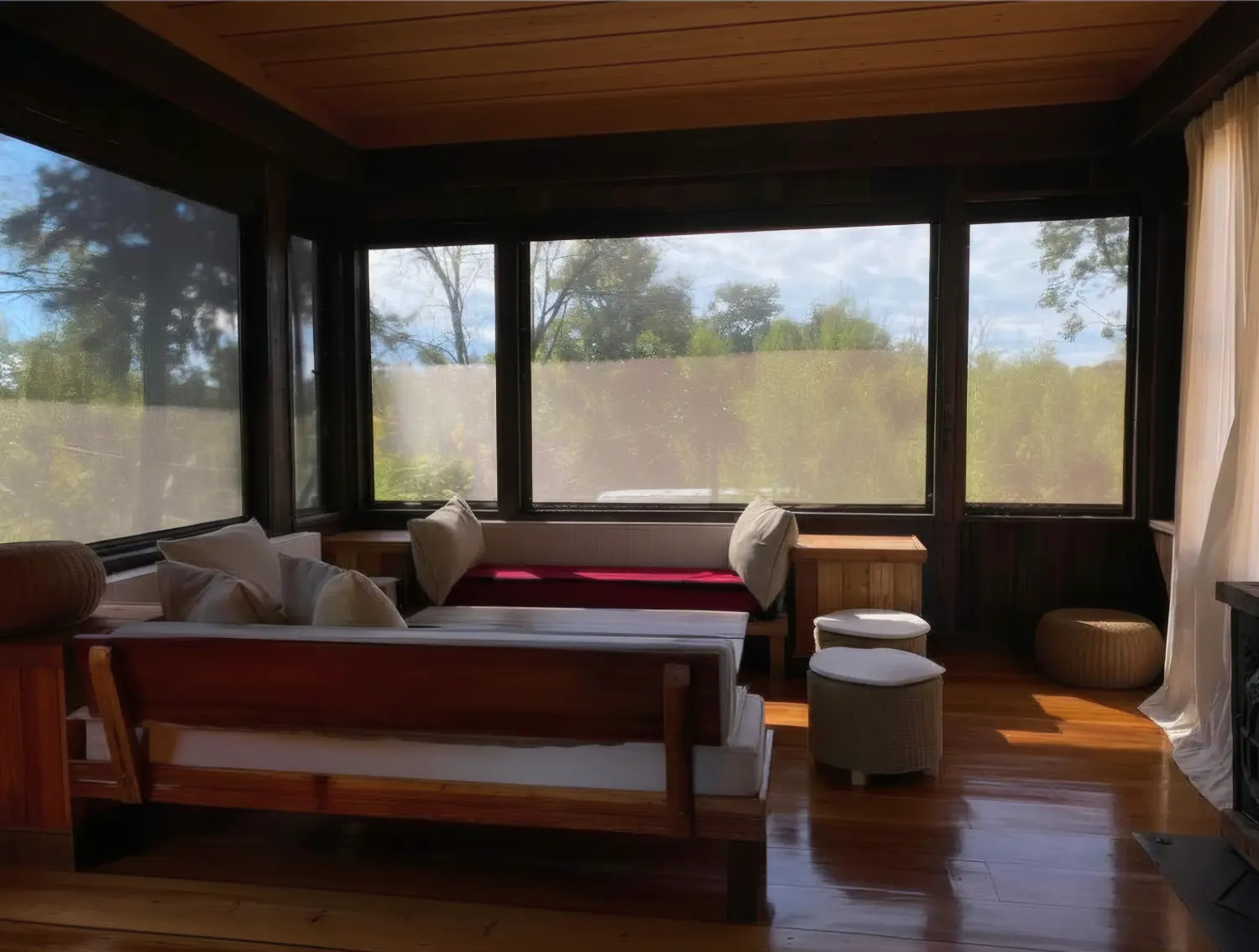 Estar rodeado de ventanales, con un sillón de madera y almohadones claros