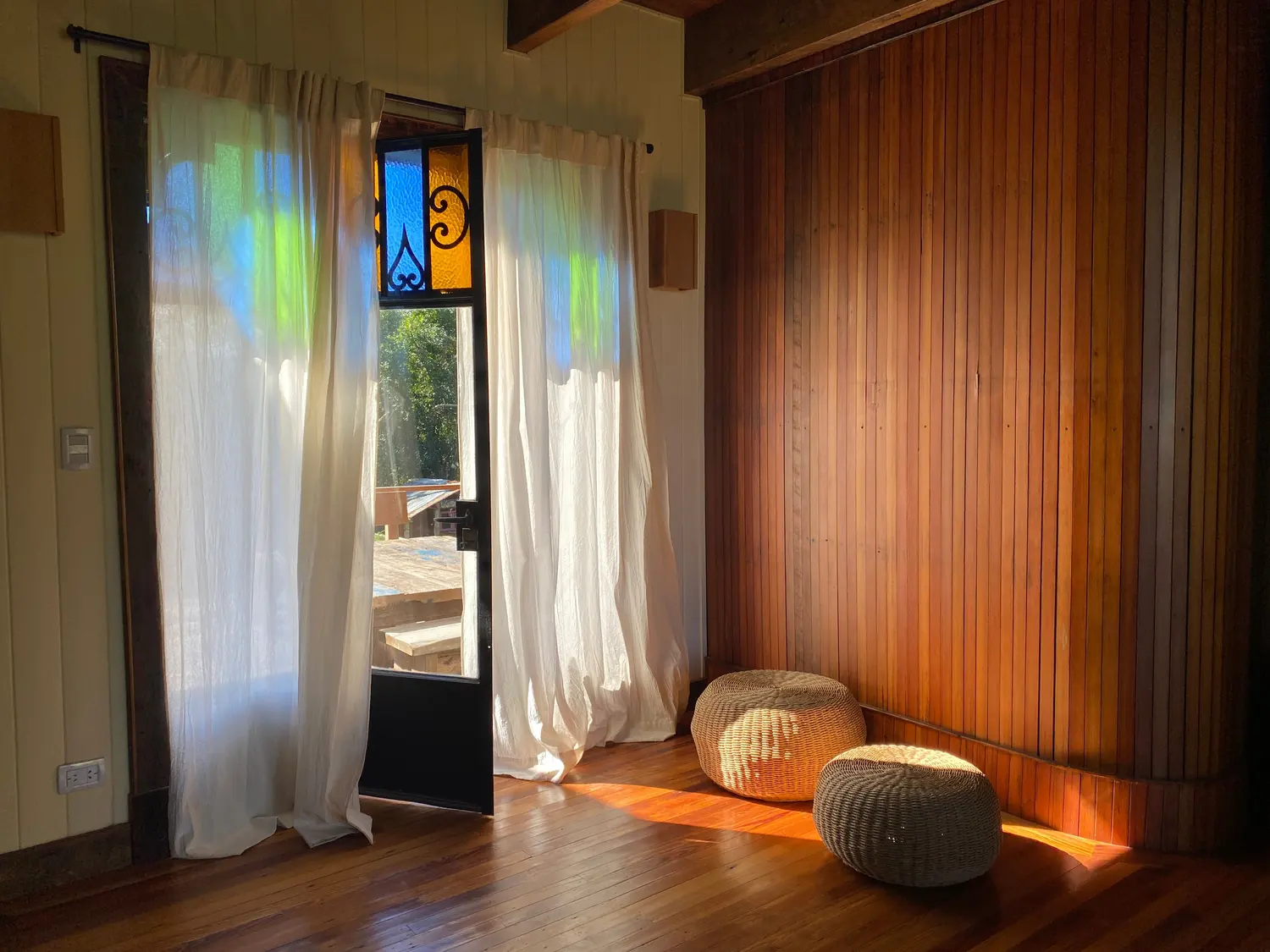 Paso interior de madera con cortinas y luz de la tarde